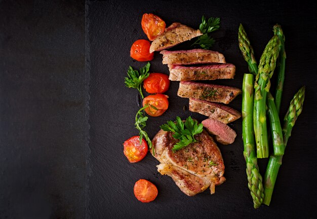 Steak juteux de boeuf mi-saignant aux épices et tomates, asperges.