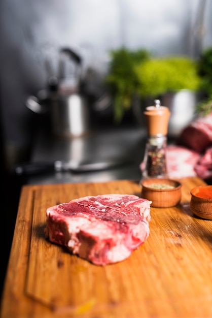 Steak de viande crue avec des épices à bord