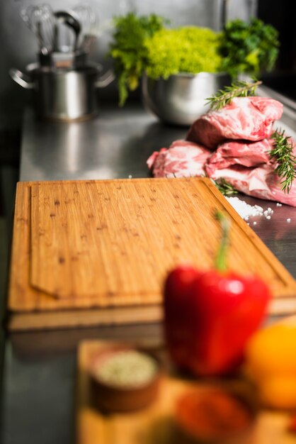 Steaks de viande crue avec planche de bois sur table