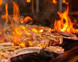 Photo gratuite steaks de viande trop cuit dans les flammes sur le gril