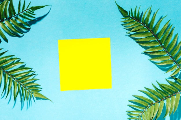 Photo gratuite sticker encadré de branches de palmier sur une surface colorée