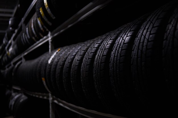 Stockage sombre complet ou grande variété de pneus neufs dans un entrepôt très fréquenté.
