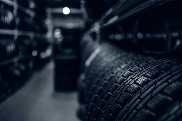 Stockage sombre complet ou grande variété de pneus neufs dans un entrepôt très fréquenté.