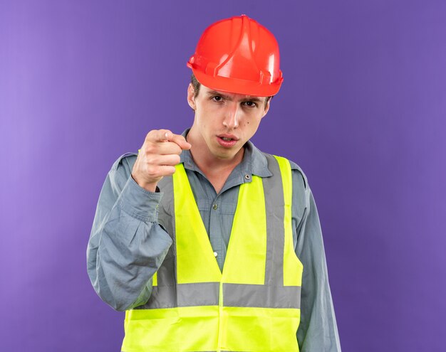 Strict regardant la caméra jeune homme de constructeur en uniforme vous montrant le geste