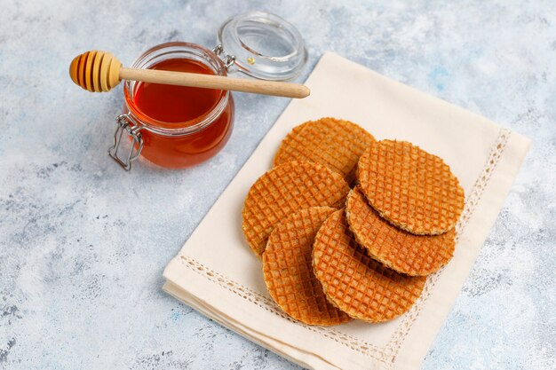 Stroopwafels, gaufres hollandaises au caramel avec thé ou café et miel sur béton
