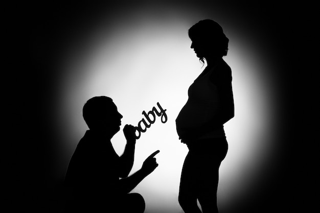 Studio Noir Et Blanc Portrait Un Jeune Couple Amoureux En Attendant Bebe Se Bouchent Homme Silhouette Et Femme Enceinte Avec Bebe Mot Portrait Noir Et Blanc Homme Et Femme Enceinte Et Inscription