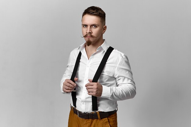 Studio photo de jeune marié élégant attrayant avec moustache de guidon et barbe s'habiller