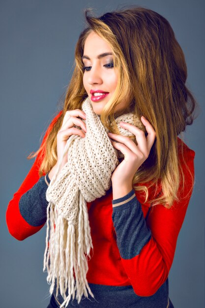 Studio portrait de mode automne hiver de belle femme élégante, vêtu d'un pull en cachemire lumineux, grande écharpe confortable, fond gris.