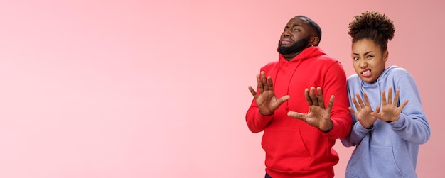 Photo gratuite studio shot paire amis afro-américains femme homme reculer dégoût n'aiment pas se sentir maladroit réticent