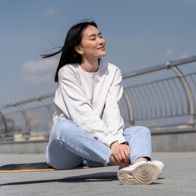 Style de vie dans le concept de ville avec femme sur longboard