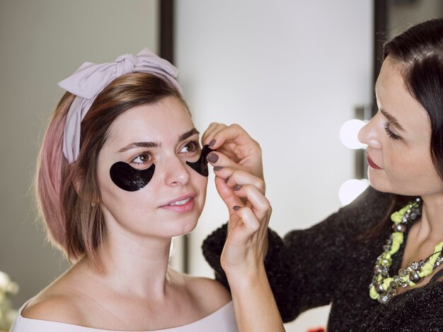 Styliste appliquant un masque sur le client