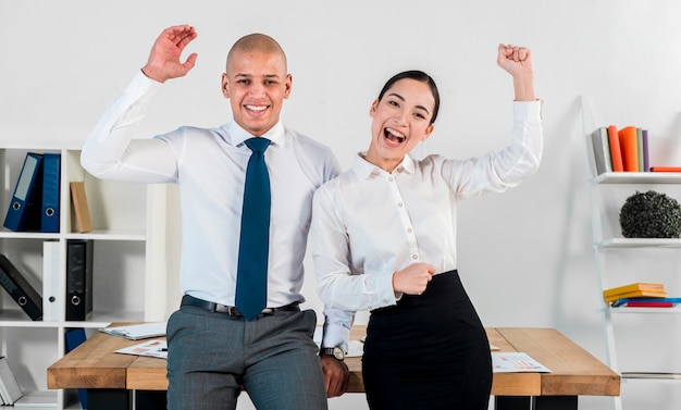 Succès multi ethnique jeune homme d&#39;affaires et femme d&#39;affaires acclamant au lieu de travail