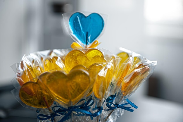 Sucettes en forme de coeur jaune et bleu au caramel