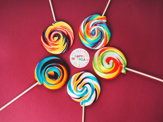 Sucettes multicolores et signe de joyeux anniversaire