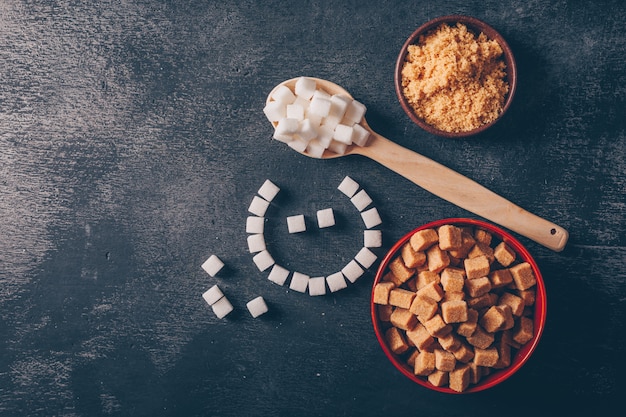 Sucre blanc et emoji dans des bols avec une cuillère à plat