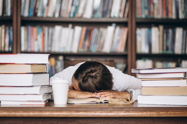 Sudent dort à la bibliothèque sur la table