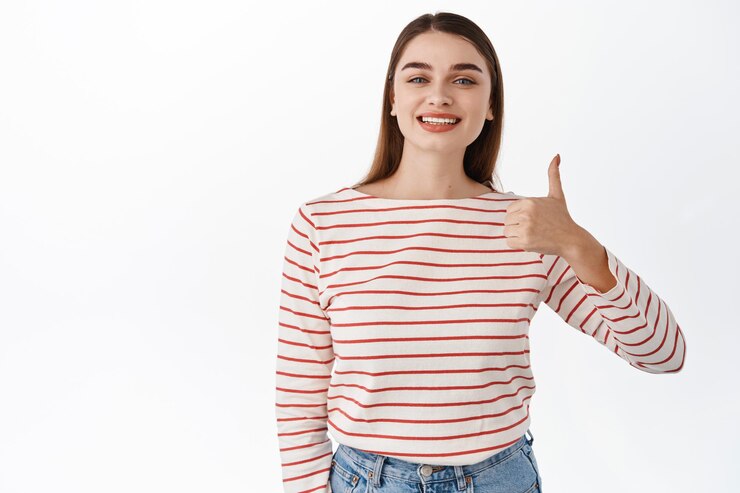 Photo gratuit super. une fille heureuse montre son approbation, aime et accepte, donne des commentaires positifs, recommande une bonne chose, exprime son opinion positive, se tient satisfaite sur fond blanc
