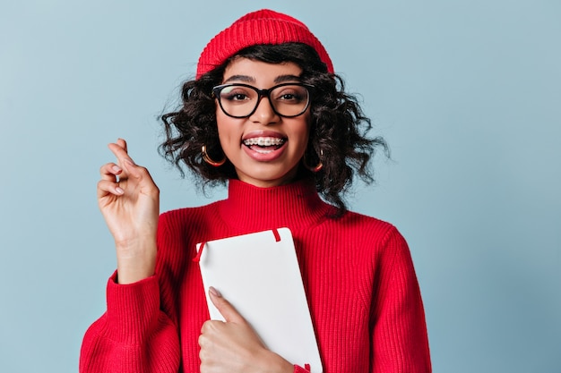 Superbe étudiant avec appareil dentaire tenant un cahier