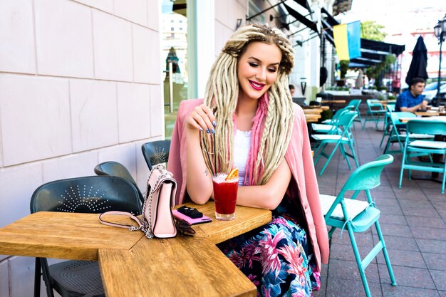 Superbe femme assez élégante posant sur la terrasse au café de la ville