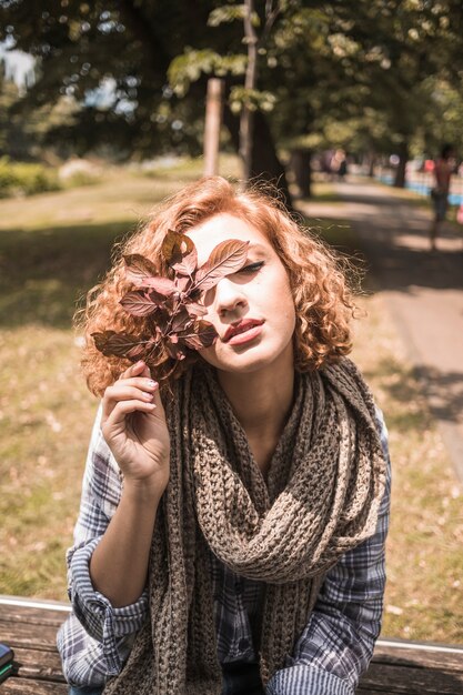 Superbe femme au gingembre avec des feuilles d&#39;automne dans le parc