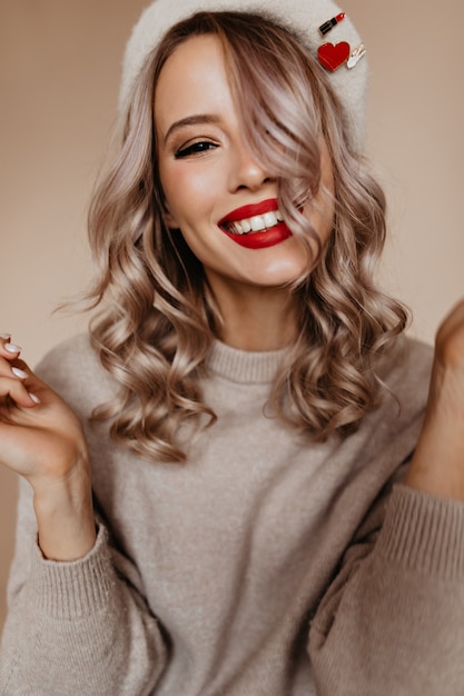 Superbe femme blonde en pull marron souriant à l'avant