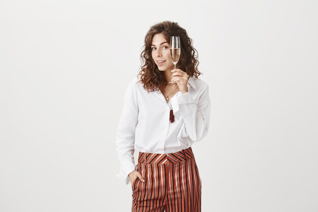 Superbe femme heureuse bénéficiant d'une fête avec verre de champagne