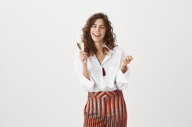 Superbe femme heureuse bénéficiant d'une fête avec verre de champagne