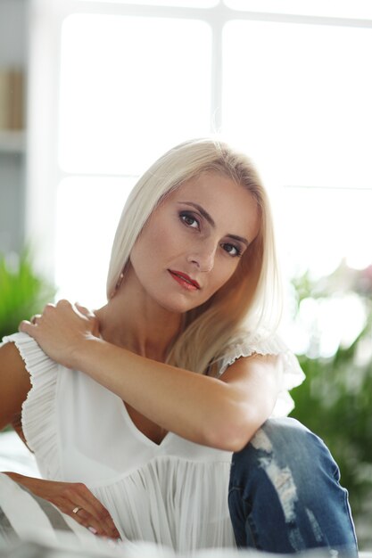 Superbe femme se détendre sur le canapé à la maison