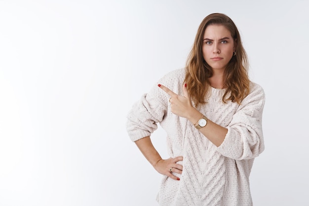 Superbe fille boudeuse exigeant des réponses pointant mécontent irrité coin supérieur gauche sur le côté déçu fronçant les sourcils contrarié