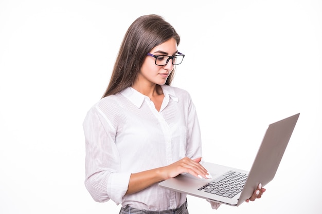 Superbe jeune étudiante en chemise blanche utilise un ordinateur portable isolé sur blanc