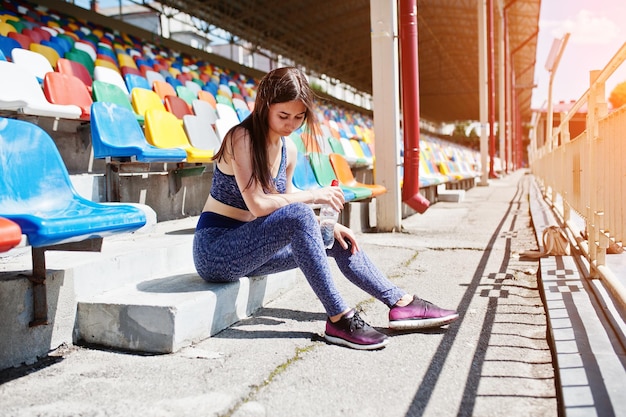 Photo gratuite superbe jeune femme en forme assise sur une chaise dans le stade