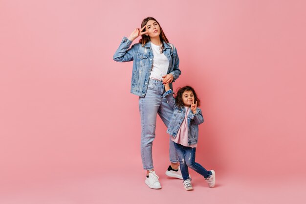 Superbe jeune femme passant du temps avec sa petite fille. Jolie mère en jeans, main dans la main avec enfant.