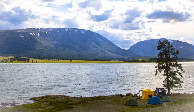 Superbe photo d'un ciel bleu nuageux et d'une chaîne de montagnes et d'un lac par une journée fraîche