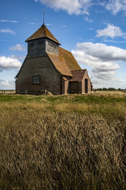 Photo gratuite superbe photo d'une vieille église et terrain herbeux au royaume-uni par temps nuageux