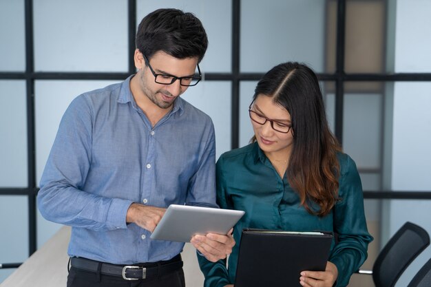 Superviseur caucasien aidant un nouvel employé asiatique.