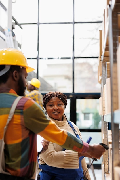 Superviseur d'entrepôt coordonnant les employés stagiaires scannant les colis de marchandises