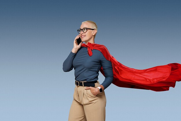 Superwoman avec cape parlant sur smartphone