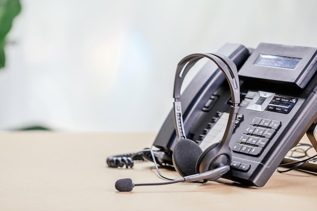 Support de communication, centre d'appels et service d'assistance client. appareils téléphoniques avec casque voip au bureau. concept d'assistance au service client (centre d'appels).