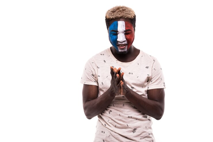 Photo gratuit support du ventilateur de l'équipe nationale afro de france prier avec visage peint isolé sur fond blanc