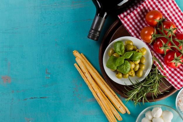 surface bleue avec des olives, des tomates et du pain croûté