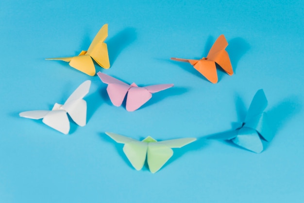 surface bleue avec des papillons en papier