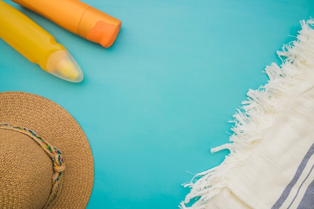 Surface bleue avec une serviette, un chapeau et des lotions