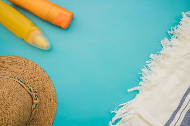 Surface bleue avec une serviette, un chapeau et des lotions