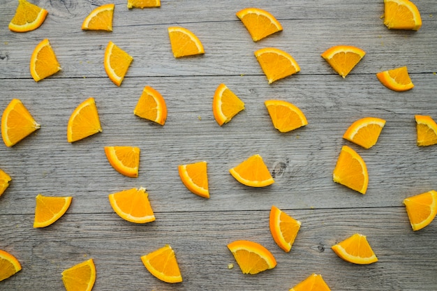 Photo gratuite surface en bois avec des pièces d'orange