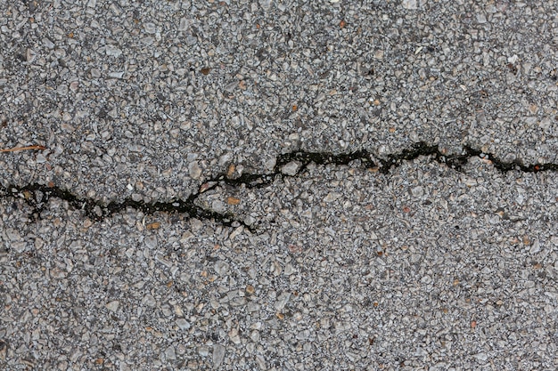 Surface de ciment avec des roches et des fissures