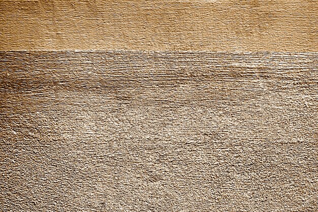 Surface du mur en béton peint à peu près or