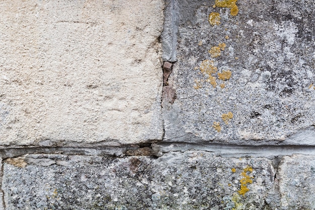 Surface du mur avec des pierres et de la mousse