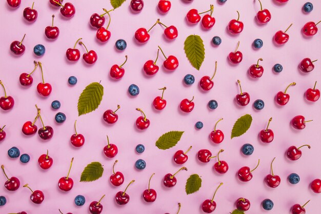 Surface d&#39;été avec des cerises, des myrtilles et des feuilles vertes