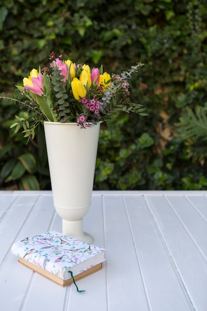 Photo gratuite surface avec des livres et vase avec des fleurs