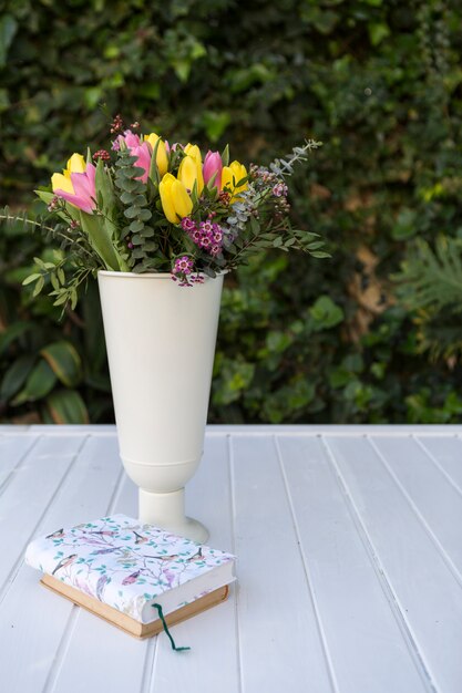 Surface avec des livres et vase avec des fleurs